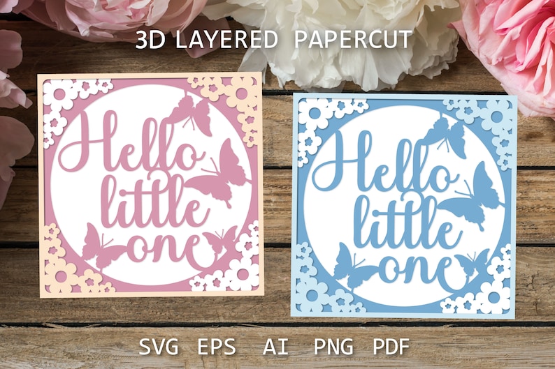 May include: Two 3D layered papercut designs with the text "Hello little one" in white. The design on the left is pink with white flowers and butterflies. The design on the right is blue with white flowers and butterflies.