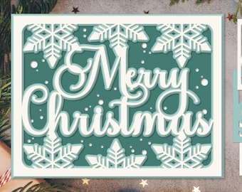 Könnte beinhalten: Eine mehrschichtige Weihnachtskarte aus Papier mit türkisblauem Hintergrund und weißen Schneeflocken. Die Worte "Merry Christmas" sind in einer mehrschichtigen, kursiven Schriftart gehalten. Die Karte ist in Weiß und Türkis gerahmt. Der untere Teil der Karte trägt den Text "SVG EPS AI PNG".