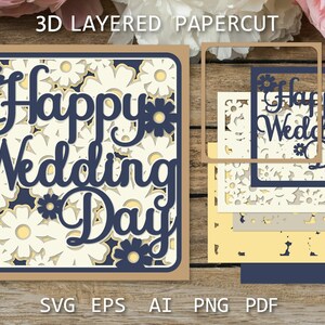 以下が含まれることがあります： 白い背景に花柄が施され、紺色の文字で「Happy Wedding Day」と書かれた3Dレイヤーペーパーカットデザイン。デザインは、茶色、白、黄色、青など、さまざまな色の紙を重ねて作られています。