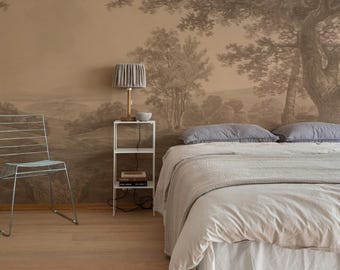 May include: A bedroom with a light brown wall mural depicting a forest scene. A white bed with a white duvet and a gray bedspread is in the foreground. A white side table with a lamp and a book is next to the bed. A metal chair is in the left corner of the room.