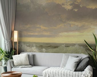 May include: A living room scene featuring a gray sofa with decorative pillows and a patterned throw blanket. The wall behind the sofa displays a large mural of a seascape with a dramatic sky. A floor lamp and potted plants add to the decor.