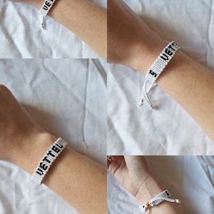 May include: White friendship bracelet with black lettering that reads "VETTEL".