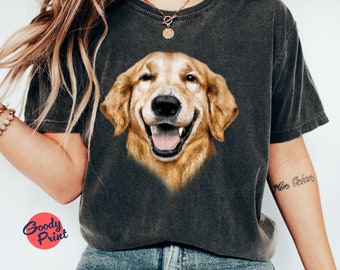 Könnte beinhalten: Dunkelgraues T-Shirt mit einem lächelnden Golden Retriever-Hund-Motiv. Das Fell des Hundes hat eine warme goldene Farbe und einen fröhlichen Ausdruck. Das Shirt hat einen Vintage-Look. Der Text "Goody Print" befindet sich in einem roten Kreis.
