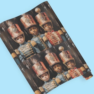May include: Wrapping paper featuring a repeating pattern of young children dressed in vintage-style military uniforms. The children wear ornate, red and gold hats and blue jackets with gold detailing. The background is dark, enhancing the rich colors of the uniforms. The overall style is reminiscent of classic holiday imagery, making it suitable for gift-wrapping during the festive season.