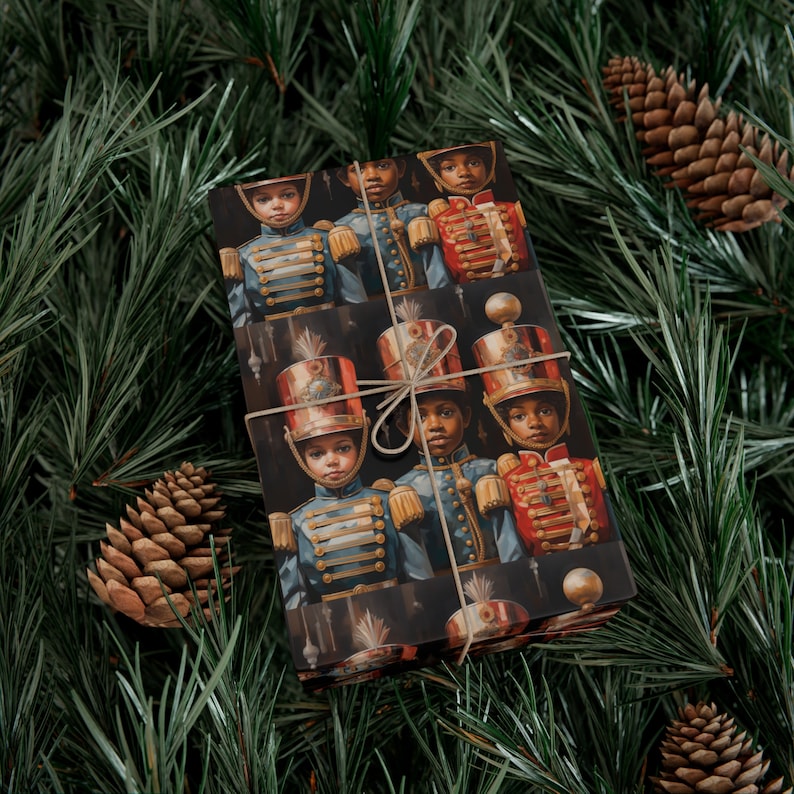 May include: Christmas gift wrap featuring a dark background with a repeating pattern of young Black children dressed in vintage military-style uniforms. The children are depicted in a regal and sophisticated manner, wearing blue, red, and gold uniforms with intricate details. The wrapping paper is tied with a simple twine bow, adding a touch of rustic elegance. This design is perfect for adding a touch of festive cheer to your holiday celebrations.