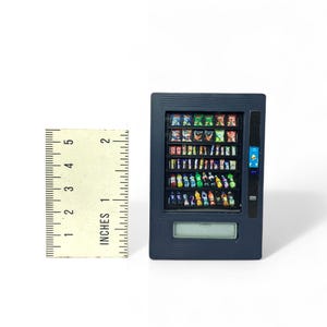 Puede incluir: Una máquina expendedora negra con un frente de vidrio que muestra una variedad de bocadillos y bebidas. La máquina tiene una pantalla digital y una ranura para monedas.