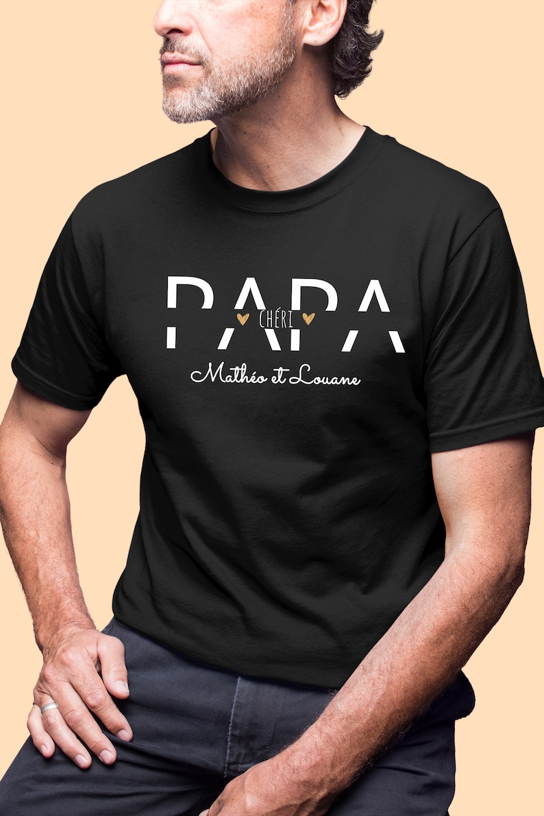 Pode incluir: Camiseta preta com texto branco que diz "Papa Ch&eacute;ri" com dois cora&ccedil;&otilde;es dourados e "Math&eacute;o et Louane" em it&aacute;lico.