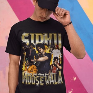 May include: Black t-shirt with a gold graphic print of a group of men wearing turbans. The graphic includes the text "Sidhu Moose Wala" and "Never Fall, Never Back Down".