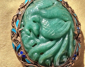 Broche antigo esculpido em jade verde com fênix, banhado a ouro vermeil e prata esterlina repoussé com filigrana e acabamento em cloisonné. Joia de exportação chinesa.