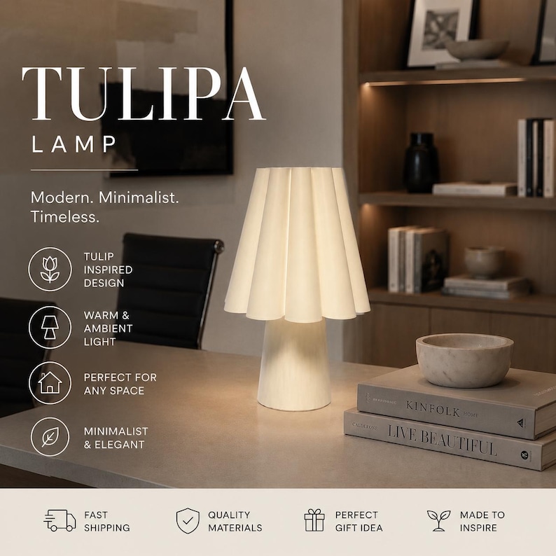 May include: A white Tulip lamp with a pleated lampshade, on a light-coloured surface. The lamp is labelled "TULIPA LAMP" with text below stating "Modern. Minimalist. Timeless."