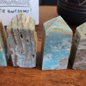 May include: Four blue and brown banded agate crystal towers, each with a unique pattern and shape.