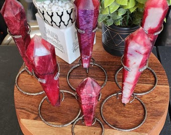 May include: Five red and white crystal points on metal stands. The crystals are all different shapes and sizes. The stands are silver and have a decorative design.