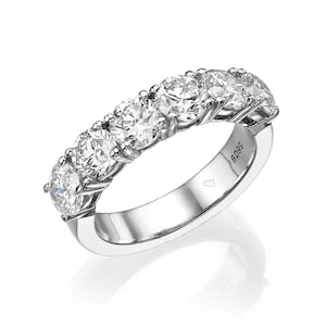 May include: A silver band with six round diamonds set in a row. The band is marked with the number "6095".