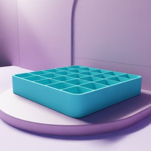 May include: A light blue plastic tray with 25 square compartments. The tray is sitting on a light purple surface.
