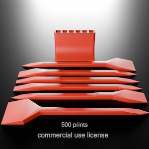 May include: A collection of orange plastic tools, including several flat, spatula-like pieces and a rectangular holder with six slots. The text "500 prints commercial use license" is visible at the bottom. The tools are arranged on a dark surface.