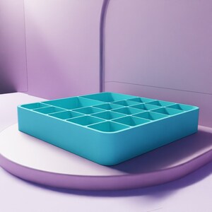 May include: A square, turquoise-colored organizer with 20 compartments. The organizer is made of a solid material and sits on a white and purple platform. The background is a gradient of purple hues.
