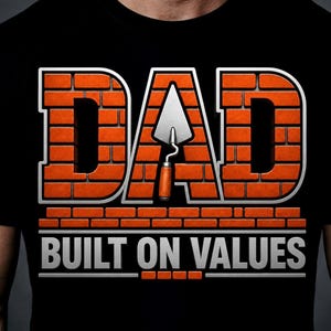 May include: Black t-shirt with the word "DAD" in large, brick-style orange letters with a silver outline. A trowel graphic is centered within the "A". Below, the text "BUILT ON VALUES" is in silver.