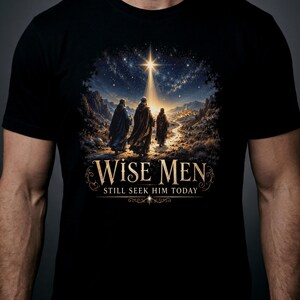 May include: A black t-shirt featuring a graphic of three figures walking along a path toward a distant town under a bright star in a night sky. Below the illustration, the text reads "WISE MEN" in large letters and "STILL SEEK HIM TODAY" below.