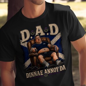 Man in chair wearing black t-shirt with Scottish flag and "DINNAE ANNOY DA" text.