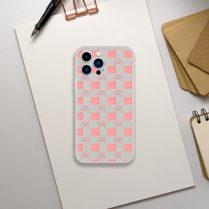 Può includere: Una custodia per telefono trasparente con un motivo geometrico rosa e bianco. La custodia ha un ritaglio per gli obiettivi della fotocamera del telefono.