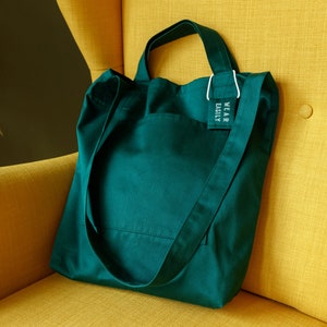 Baumwolltasche mit zwei Taschen, kurzen Henkeln, langem Körpergurt und Lavendelkissenanhänger