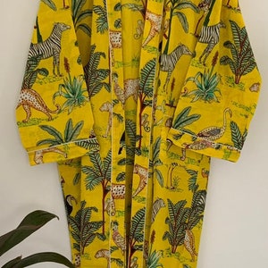 May include: A yellow cotton robe with a white trim. The robe features a jungle print with zebras, leopards, toucans, and palm trees.