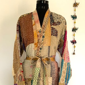 May include: A patchwork robe with a brown, yellow, and blue color scheme. The robe has a long, flowing design and a tie belt. The robe is made of a soft, comfortable fabric.