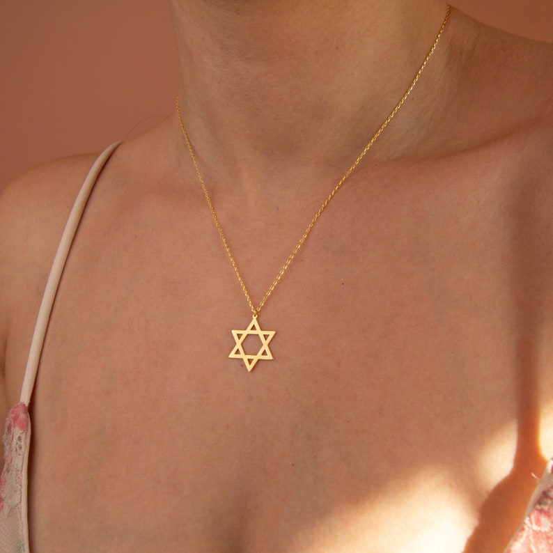 A person wearing a gold Star of David necklace