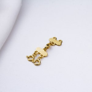 May include: Gold-toned metal jewelry extender with two loops and a lobster clasp.