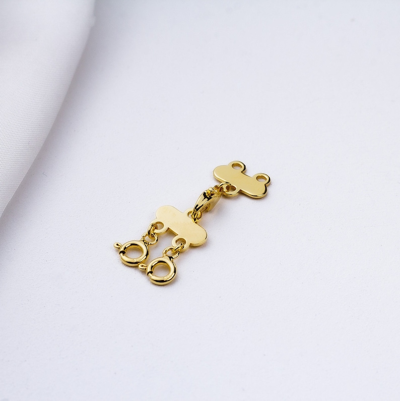 May include: Gold-toned metal jewelry extender with two loops and a lobster clasp.