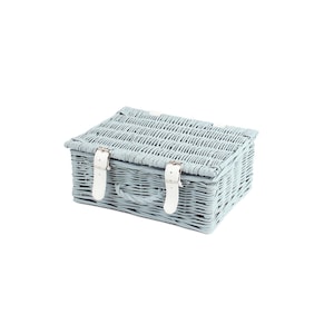 May include: A light blue wicker picnic basket with white leather straps and buckles.