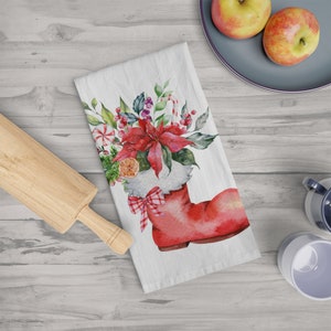 May include: A red Christmas stocking filled with a poinsettia, greenery, candy canes, and an orange slice. The stocking has a white cuff with a red and white checkered bow.
