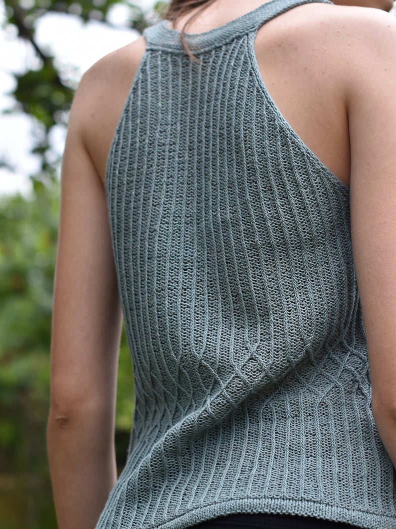 Peut inclure: Un d&eacute;bardeur sans manches en maille vert sauge avec une texture c&ocirc;tel&eacute;e et un col halter.