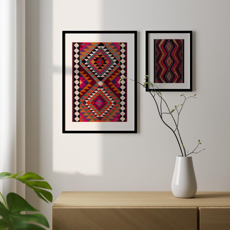 May include: Two framed prints of colorful geometric patterns in shades of red, orange, pink, blue, and black. The prints are hanging on a white wall above a wooden shelf.