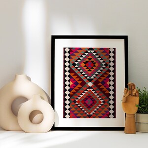 May include: A framed print of a colorful geometric pattern in shades of red, orange, pink, green, and black. The print is set against a white wall with two decorative ceramic vases and a wooden hand sculpture.
