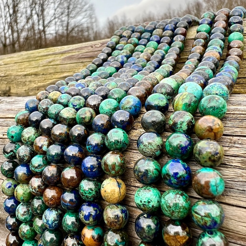 Azurite stone beads strands laid on bright wood surface in outdoor and pictured under natural day light.