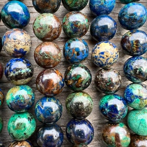 Azurite stone beads strands laid on bright wood surface in outdoor and pictured under natural day light. pictured from a very close look