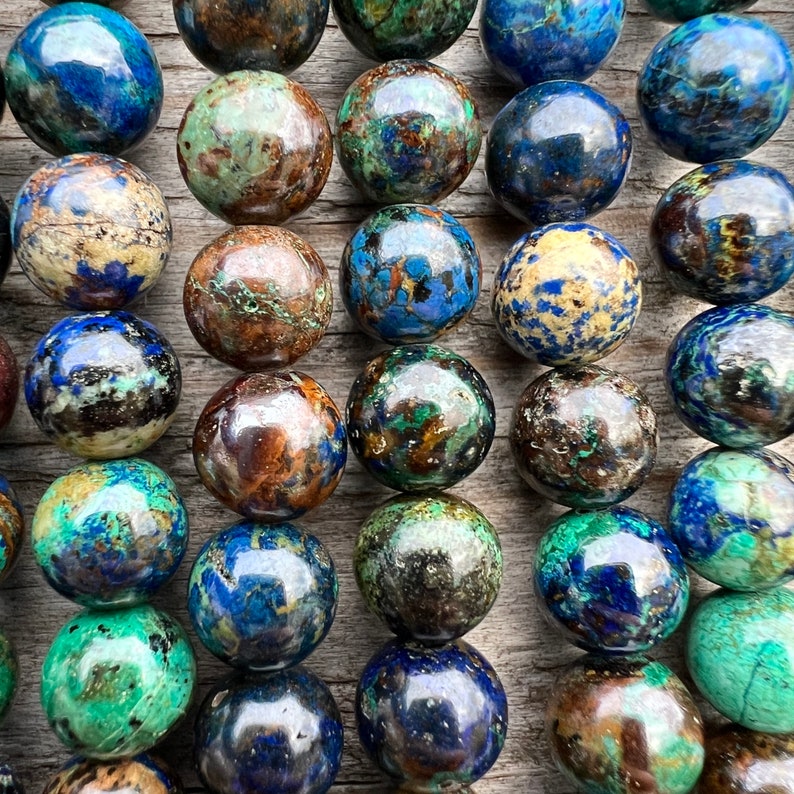 Azurite stone beads strands laid on bright wood surface in outdoor and pictured under natural day light. pictured from a very close look