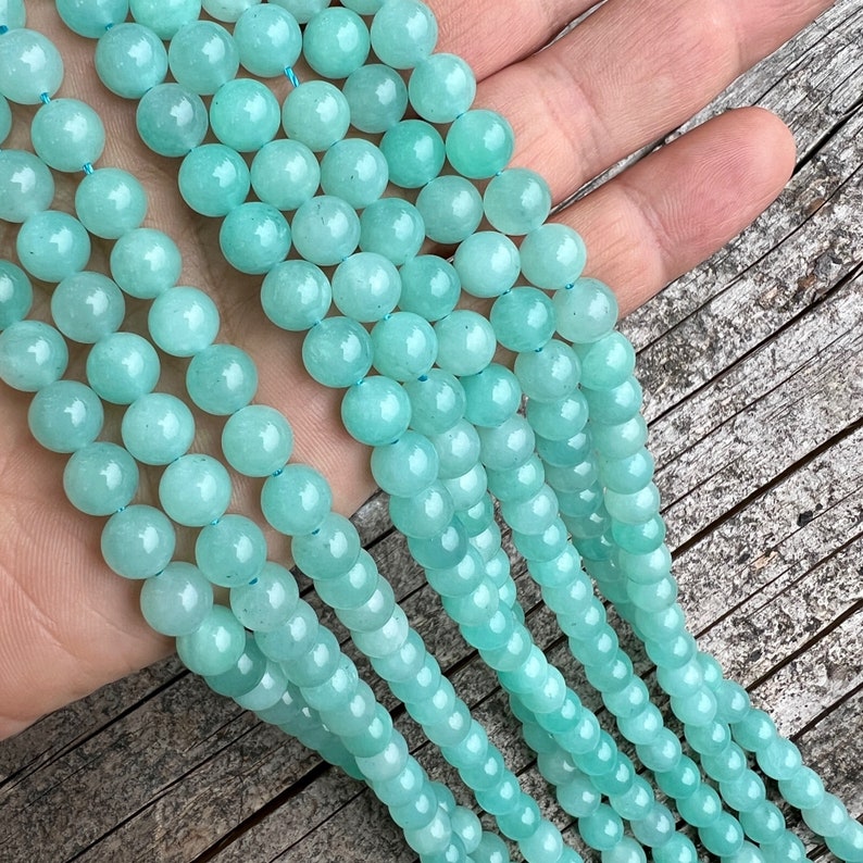 amazonite beads strands held in hand on a trunk