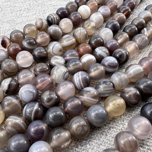 Botswana agate stone beads strands laid on a gray background