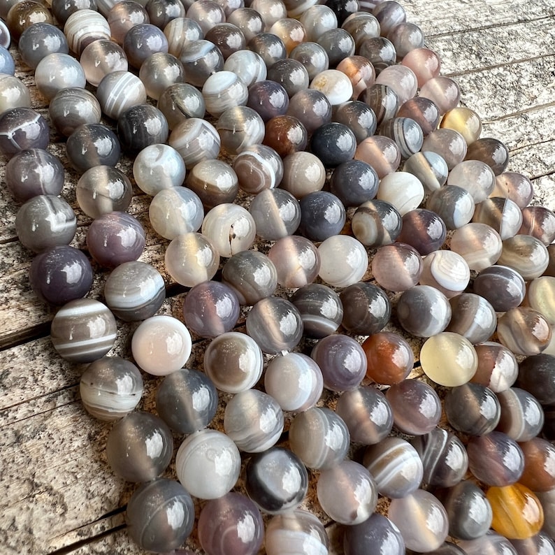 Botswana agate stone beads strands laid on a trunk
