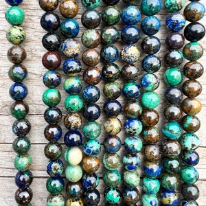 Azurite stone beads strands laid on bright wood surface in outdoor and pictured under natural day light.