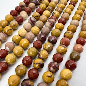 May include: A strand of faceted gemstone beads in shades of brown, yellow, and red. The beads are round and have a textured surface.