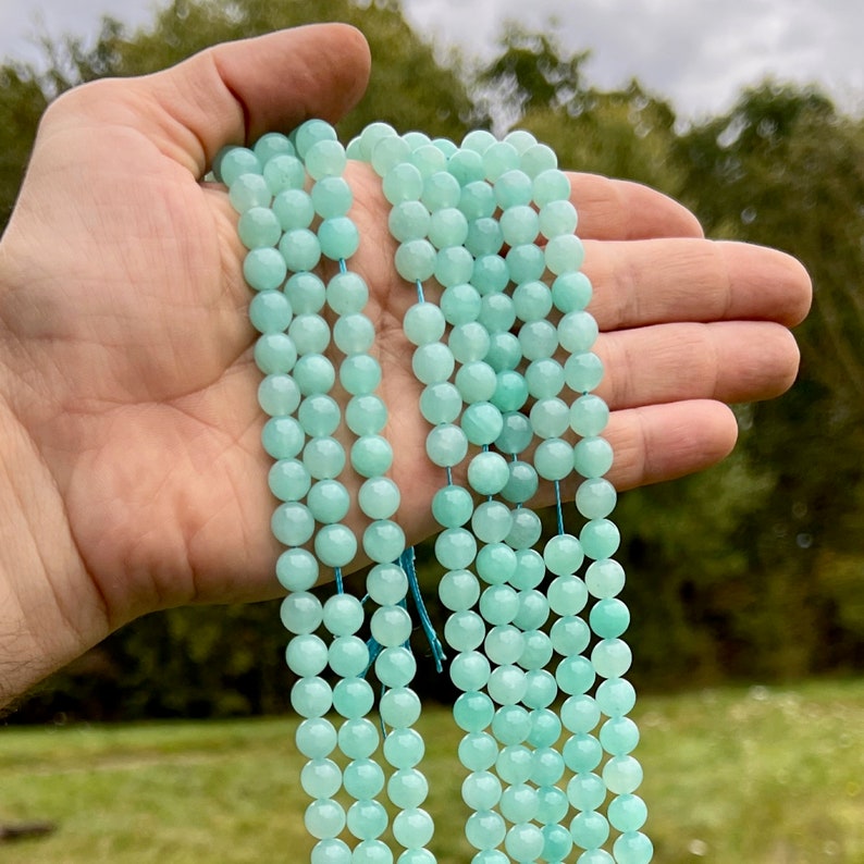 amazonite beads strands held in hand in outdoor under natural light