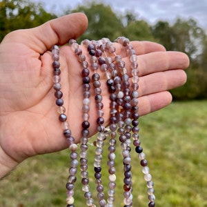 6mm Botswana agate stone beads strands held in hand in outdoor under natural light