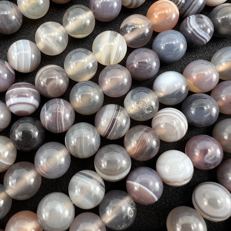 Botswana agate stone beads strands laid on a black background from a closer look