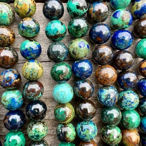 Azurite stone beads strands laid on bright wood surface in outdoor and pictured under natural day light.