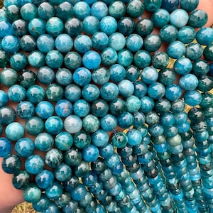 Apatite stone beads strands held in hand in outdoor under natural light pictured from a close look