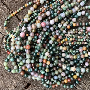 Indian agate stone beads strand stacked on a trunk pictured from above