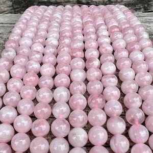 Madagascar rose quartz beads strands on top of a trunk